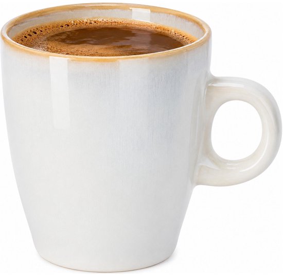 Witte mok met spikkels en gouden rand, gevuld met koffie.