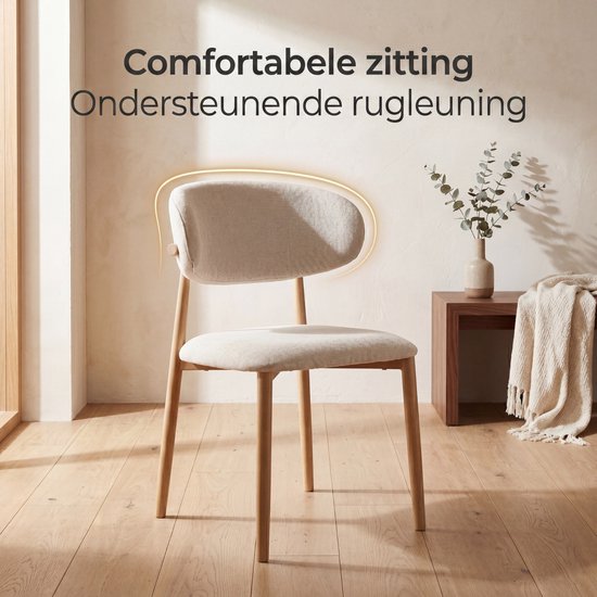 Beige eetkamerstoel met stoffen zitting en rugleuning, en houten frame, in een interieur.