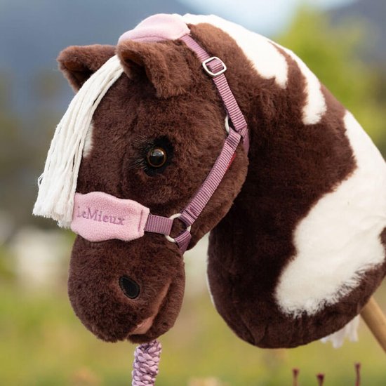 Bruin met witte vlekken hobby horse met roze halster en 'LeMieux' tekst.