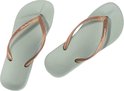Lichtgroene Ipanema teenslippers met koperkleurige bandjes.