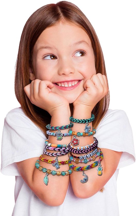 Lachend meisje met zelfgemaakte Stitch-armbanden met kleurrijke bandjes en bedeltjes.