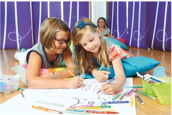 Twee meisjes liggen op de grond en kleuren met STABILO Trio A-Z stiften. Een derde meisje kijkt toe.