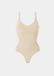Beige bodysuit met V-hals en een gedetailleerd inzetstuk op de borst.