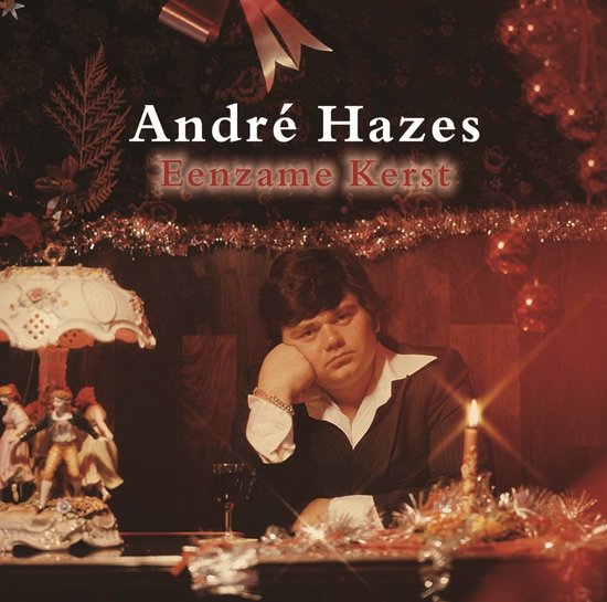André Hazes zit aan tafel, eenzaam met Kerst, met kaarslicht en kerstdecoratie.