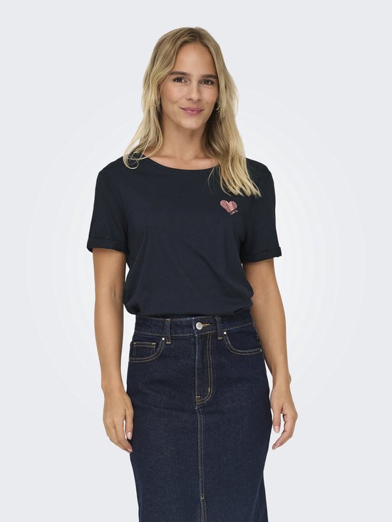 Model met blond haar lacht en draagt een donkerblauw T-shirt met een roze glitter hartje.