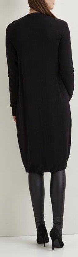Zwarte gebreide lange vest, achterkant zichtbaar, gedragen met legging.