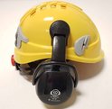 Gele veiligheidshelm met zwarte gehoorbeschermers, gemarkeerd met "Ear Defender ED 2C".