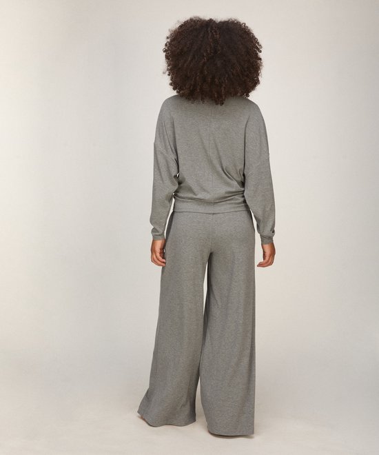 Model op de rug gezien in grijze loungewear set met wijdvallende broek.