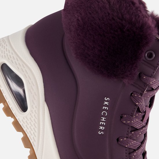 Detail van paarse Skechers-laars met imitatiebontkraag, veters en wit zoolgedeelte met luchtkussen.