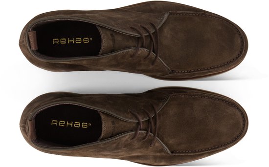 Paar bruine suède chukka boots, van bovenaf gezien, met vetersluiting en logo op binnenzool.
