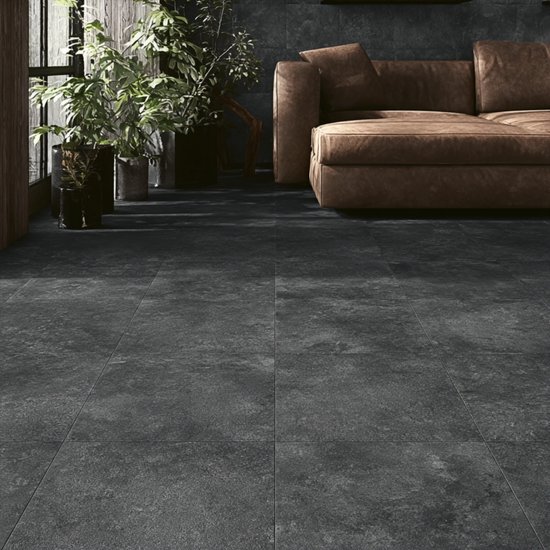 Donkergrijze tegels met natuurlijke textuur in een stijlvol interieur met bruine bank.