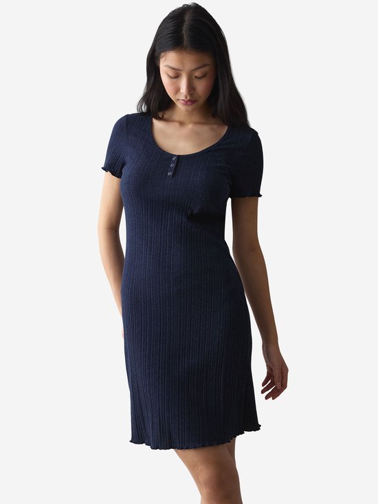 Model draagt een donkerblauwe geribbelde nachtjapon met knoopjes, korte mouwen en een zoom met ruches.