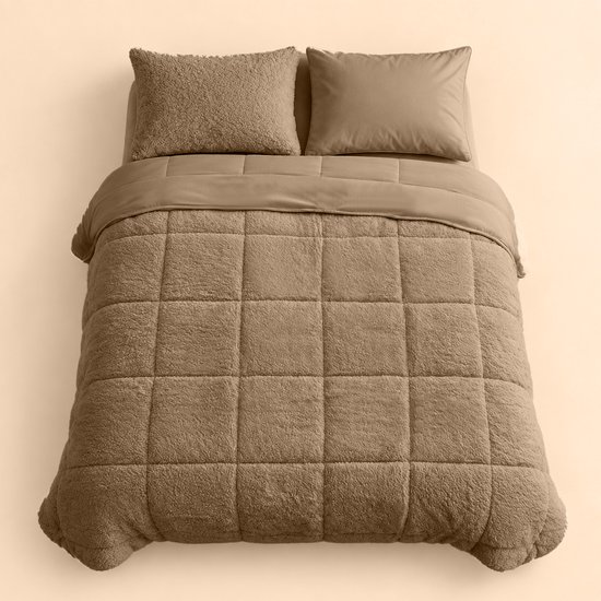 Een taupe teddy dekbed met ruitpatroon en twee bijpassende kussens op een bed.