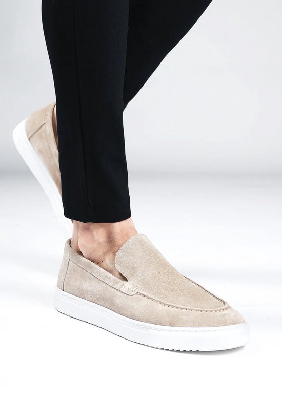 Beige suède loafers gedragen met een zwarte pantalon.