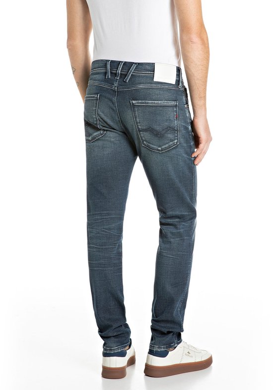 Achterzijde van een model in donkerblauwe Replay jeans, met wit merklabel op de tailleband.