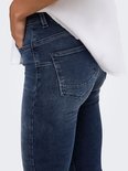 Detail van de achterzakken van de blauwe jeans met push-up pasvorm en wit overhemd.
