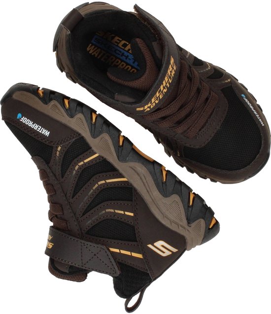 Bruine Skechers wandelschoenen met zwarte mesh en gele accenten. 'WATERPROOF' op de zijkant.