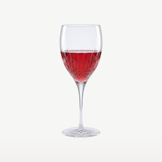 Un verre à vin rempli de vin rouge, avec une tige facettée et un motif diamant sur le calice.