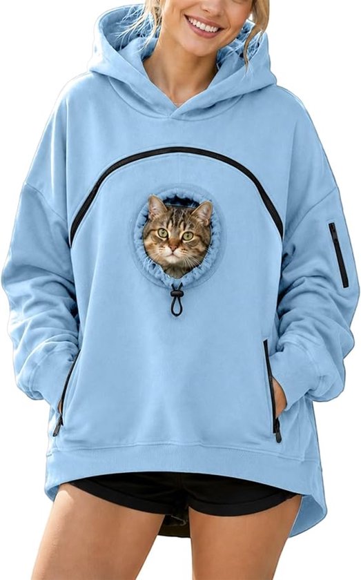 Vrouw in een lichtblauwe hoodie met een kat die uit de buidel aan de voorzijde kijkt.