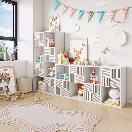 Kinderkamer met witte modulaire kasten, decoraties en speelgoed. Sommige kastvakken hebben een patroon van verticale ribbels.