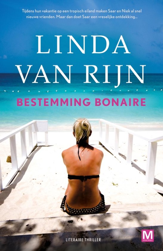 Een vrouw met blond haar in een zwart-witte bikini zit op een wit trapje op een strand. De zee is azuurblauw en de lucht is helder. LINDA VAN RIJN BESTEMMING BONAIRE.