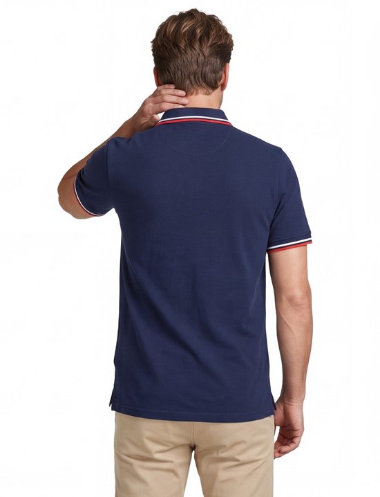 Donkerblauw poloshirt met rode en witte strepen op de kraag en mouwen, gedragen door een man.