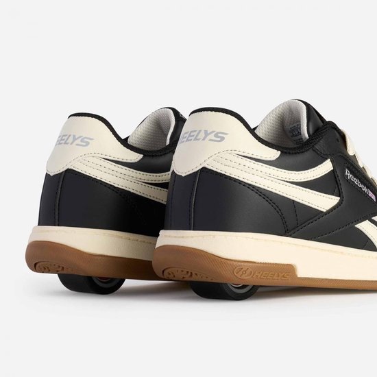 Zicht op de achterkant van twee zwarte Heelys sneakers met crème accenten.