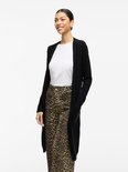 Vrouw in luipaardprint broek en zwarte lange vest.