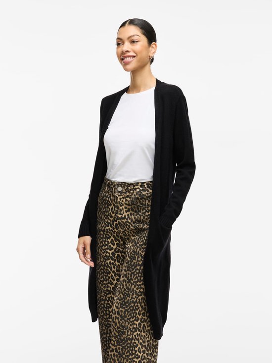 Vrouw in luipaardprint broek en zwarte lange vest.