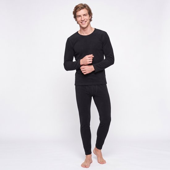 Model in een zwarte thermo ondergoed set, lachend naar de camera.