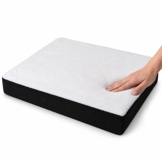 Hand drukt op de zachte, witte fleece bovenkant van een zwart zitkussen op een witte achtergrond.