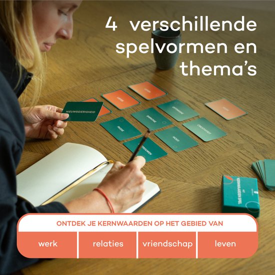 Een persoon schrijft in een notitieboekje terwijl andere kaarten van Het Kernwaarden Spel op tafel liggen.