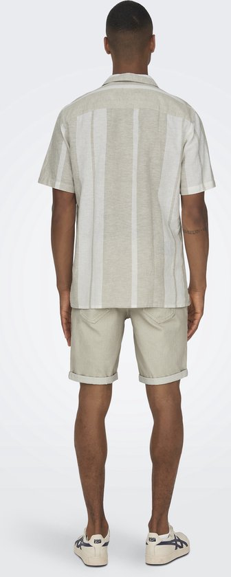Achterkant man in licht beige hemd met verticale strepen, beige shorts.