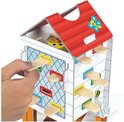 Een hand steekt een houten stokje in het kippenhok spel Happy Chickens.