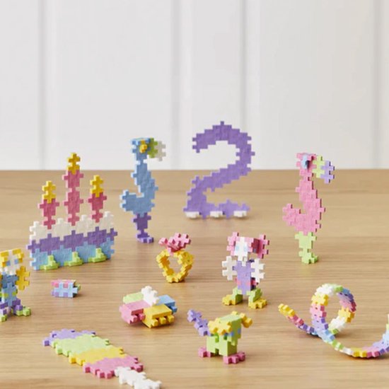Plus-Plus bouwwerken: taart, zeedieren, cijfer 2, ring, huisje, figuurtjes en een boog.