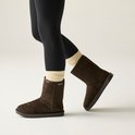 Dames laarzen in bruin suède met een beige gebreide boord, gedragen met zwarte legging.