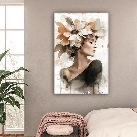 Une femme portant une grande coiffe florale dans des tons doux de beige et de brun, vêtue d'un haut noir, accrochée dans une chambre.