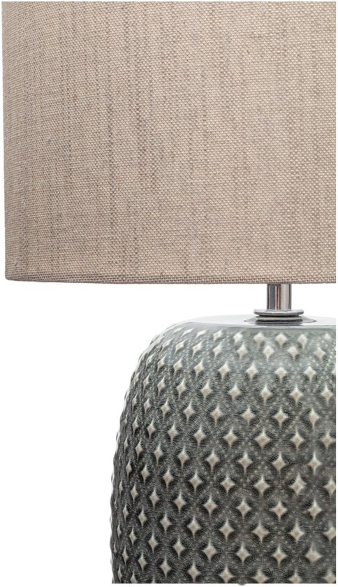 Grijze tafellamp met een beige stoffen kap en een decoratieve, geribbelde voet met ruitpatroon.