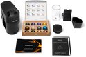Zwarte Nespresso Vertuo Pop koffiemachine met accessoires: capsules, waterreservoir, boekjes en stroomadapter.