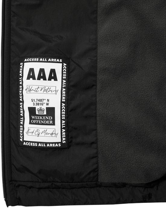 Binnenkant van een zwarte jas met label met "Access All Areas", "AAA Admit Nothing", coördinaten en het Weekend Offender logo.