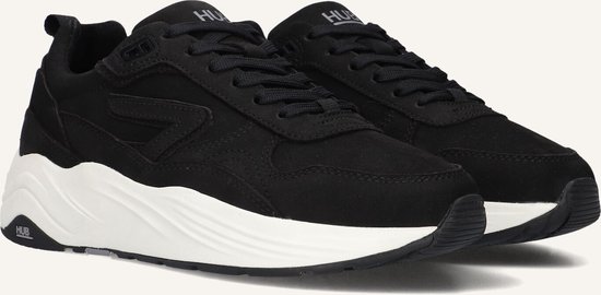 Close-up van zwarte HUB sneakers met dikke witte zolen en veters.
