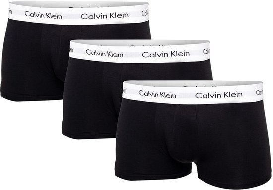 Drie zwarte Calvin Klein trunks, van schuin van voren, met witte taillebanden met logo.