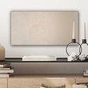 Beige canvas met cirkelvormige patronen, hangend boven een zwarte plank met boeken en decoraties.