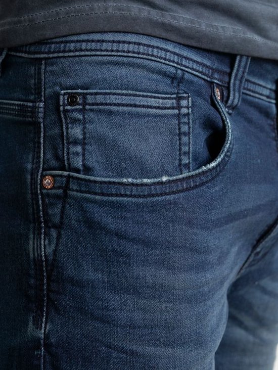 Close-up van de zak van een blauwe spijkerbroek met naden en een metalen knoop.