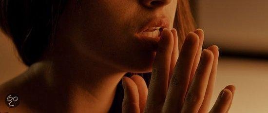 Gros plan d'une femme avec ses mains près de sa bouche.