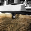 Close-up van een bovenfreesmachine die hout bewerkt, met rondvliegend zaagsel.