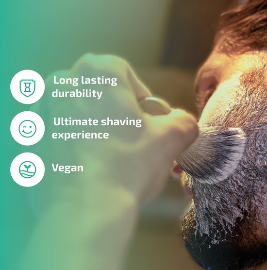 Mannelijk gezicht met scheerschuim. Hand houdt scheerkwast met bruin-witte haren. Tekst: 'Long lasting durability', 'Ultimate shaving experience', 'Vegan'.