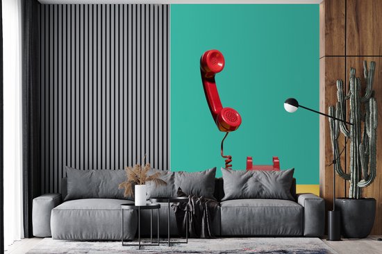 Papier peint - Papier peint Un téléphone rétro rouge sur fond jaune devant un Papier peint photo végétal - Largeur 200 cm x hauteur 300 cm