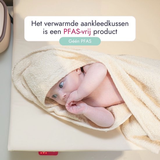 Een pasgeboren baby wordt omhuld door een zandkleurige handdoek. Het aankleedkussen is PFAS-vrij.