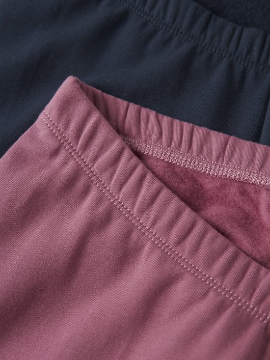 Close-up van de tailleband van een roze en donkerblauwe legging met fleece voering.